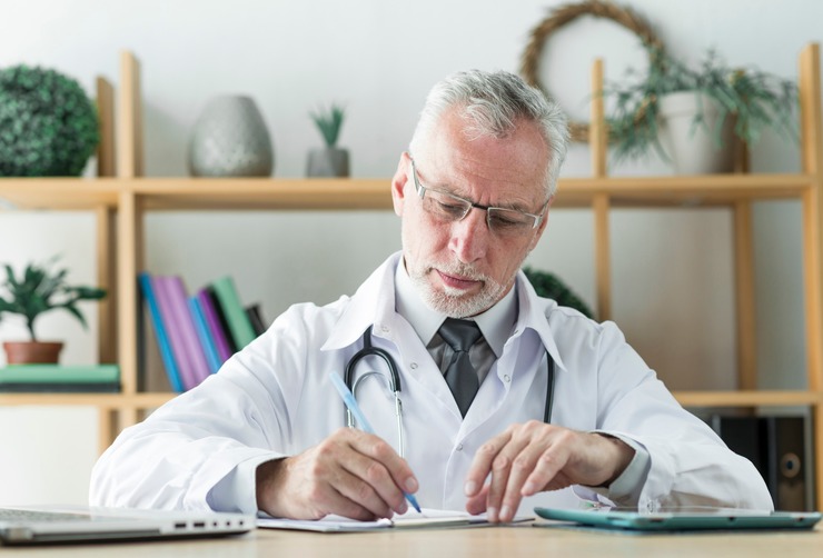 Clinician writing notes at a desk